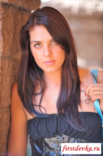 Брюнетка раздевается возле старинного здания